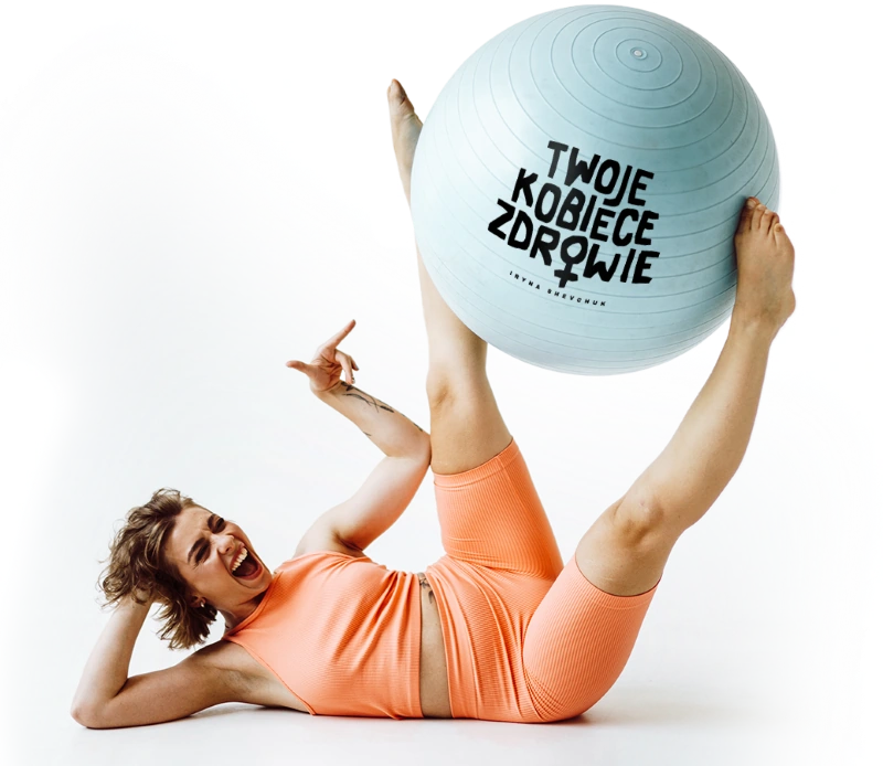 Kobieta w pomarańczowym stroju fitness z piłką gimnastyczną